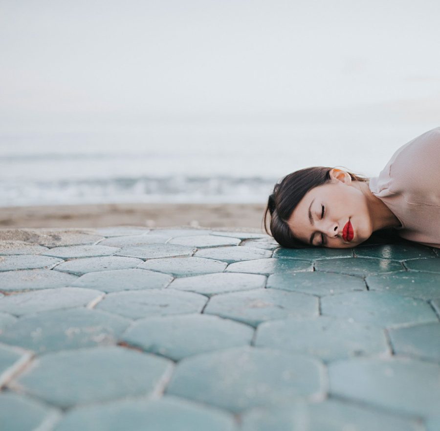 mujer tumbada suelo azulejos playa